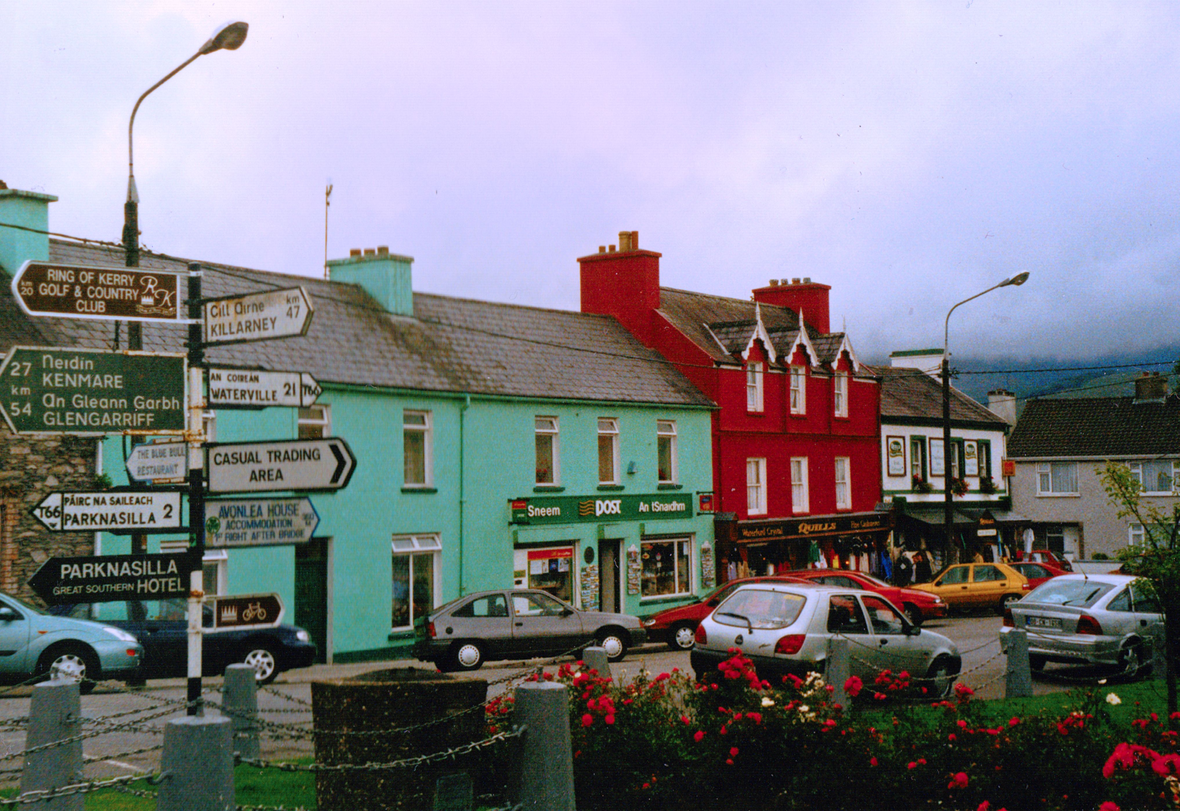 Vibrant street scene in Sneem, Ireland with colorful buildings and signage.