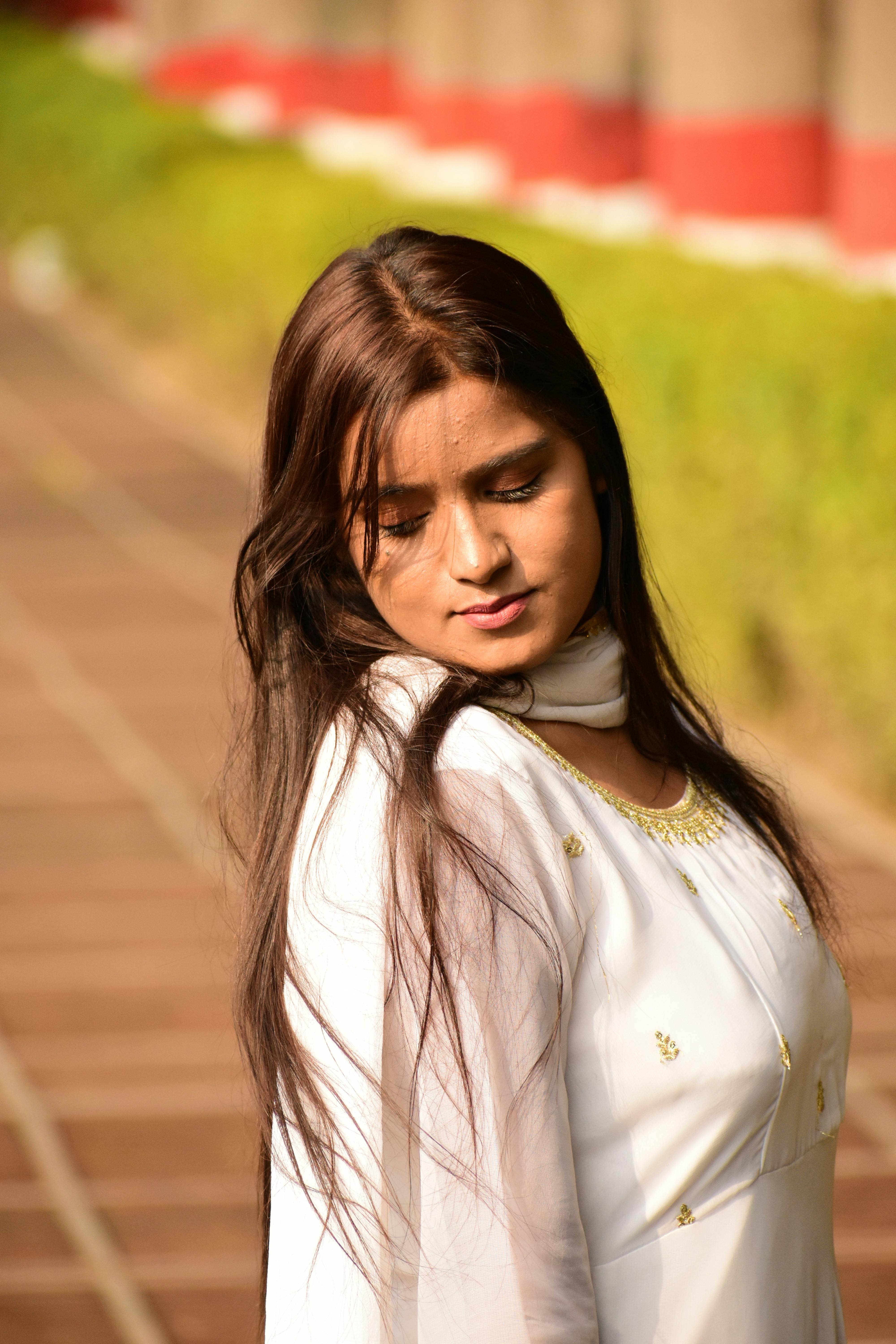Young woman in traditional attire outdoors, captured in warm sunlight.