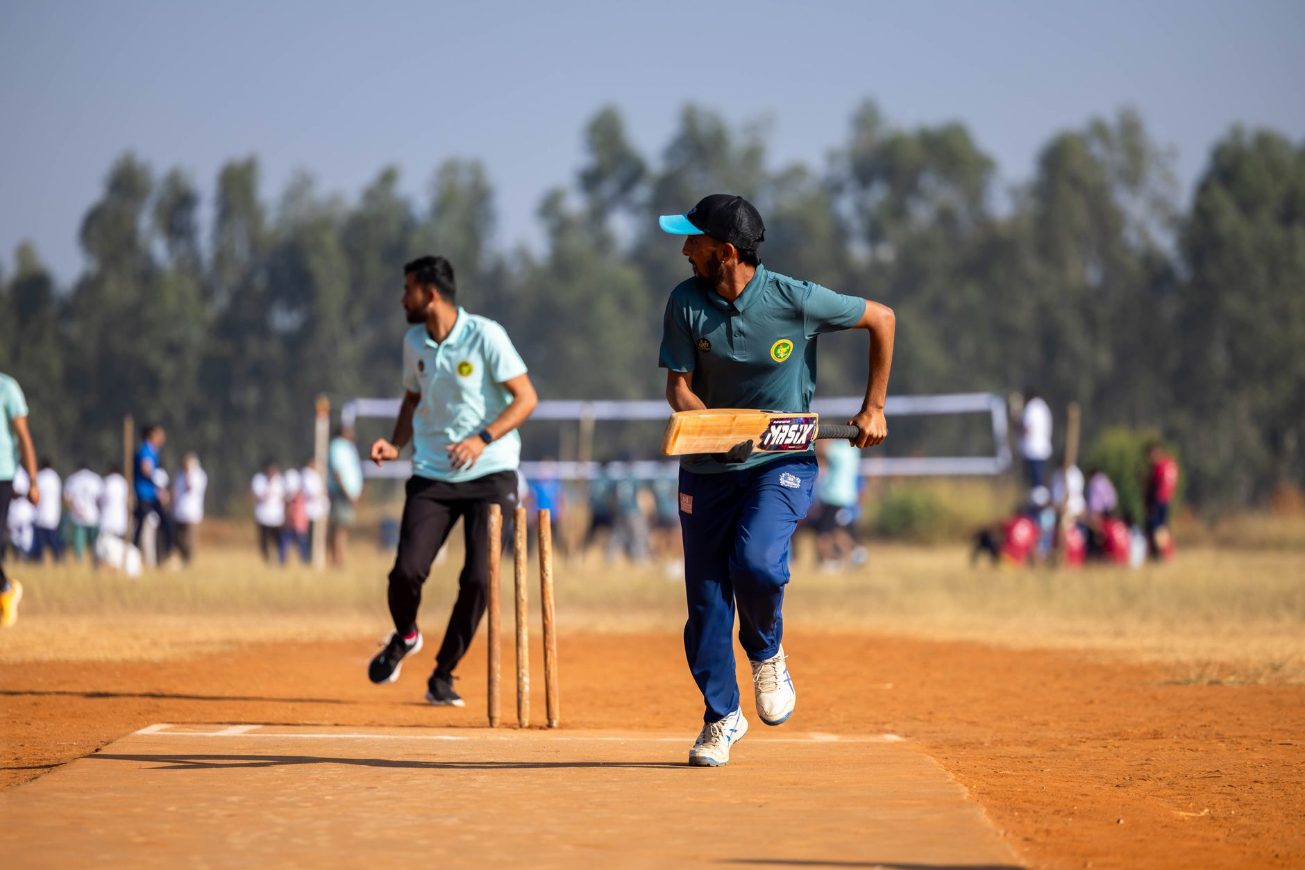 क्लब क्रिकेट प्रशिक्षक टैबलेट पर गेंद की गति और लक्ष्य क्षेत्र प्रतिशत का विश्लेषण करते हुए