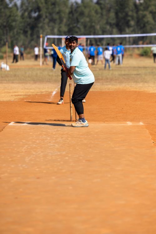 Free A man prepares to bat during a friendly outdoor cricket match on a sunny day. Stock Photo
