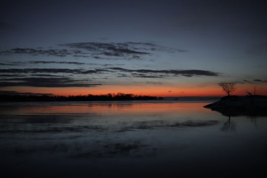 Tranquil twilight scene with a stunning reflection over calm waters, capturing a serene evening ambiance.