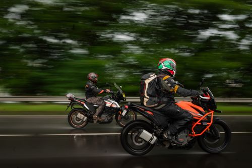 Free Exciting long exposure shot of motorcyclists racing on a wet road in Maharashtra, India. Stock Photo