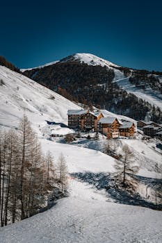 Charming mountain chalets set against a snowy winter landscape under clear blue skies.