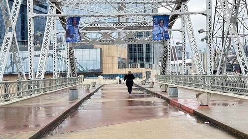 Free A person walks on the iconic John Seigenthaler Pedestrian Bridge on an overcast day in Nashville, TN. Stock Photo