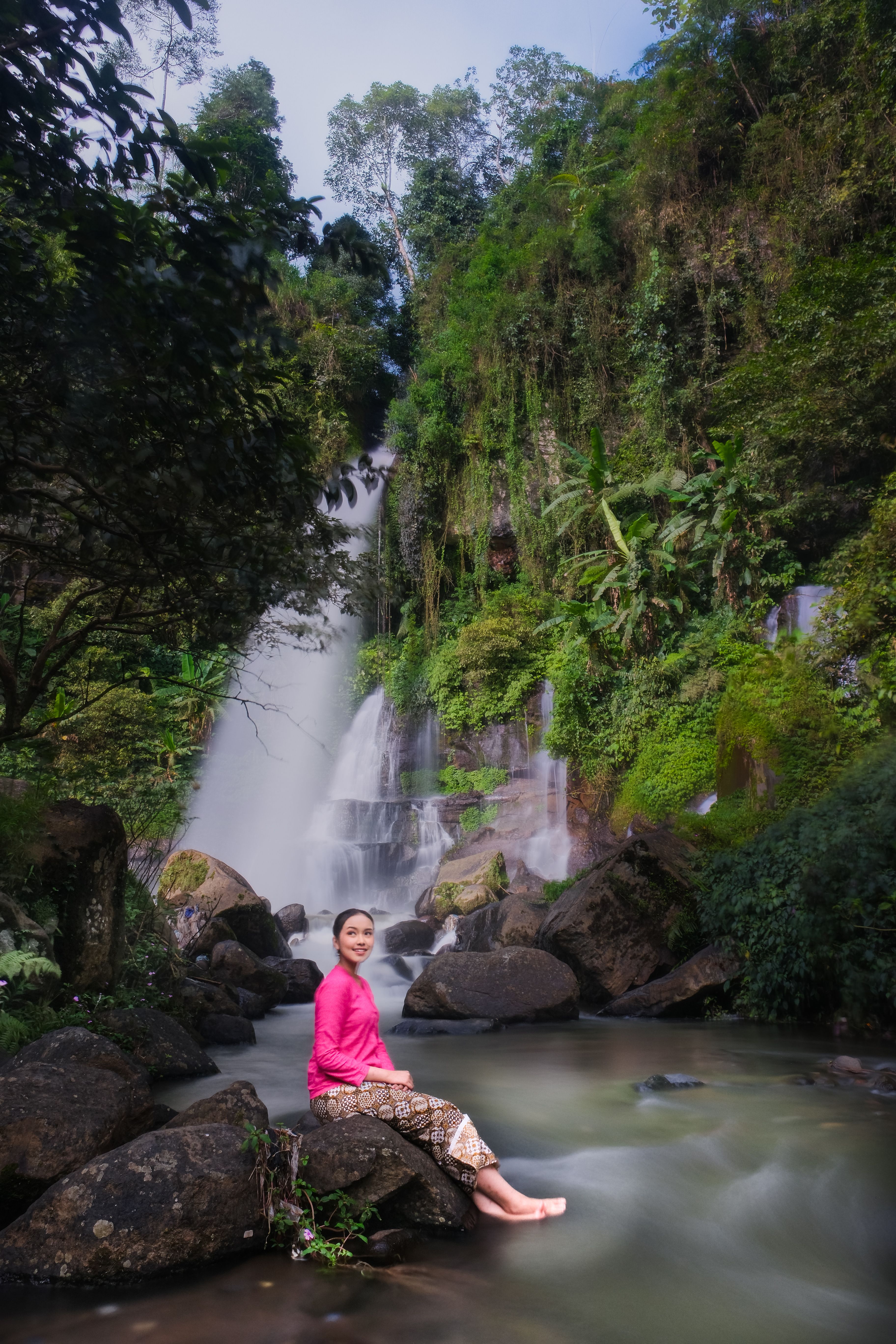 Woman Enjoying Waterfall in Jawa Barat's Lush Nature