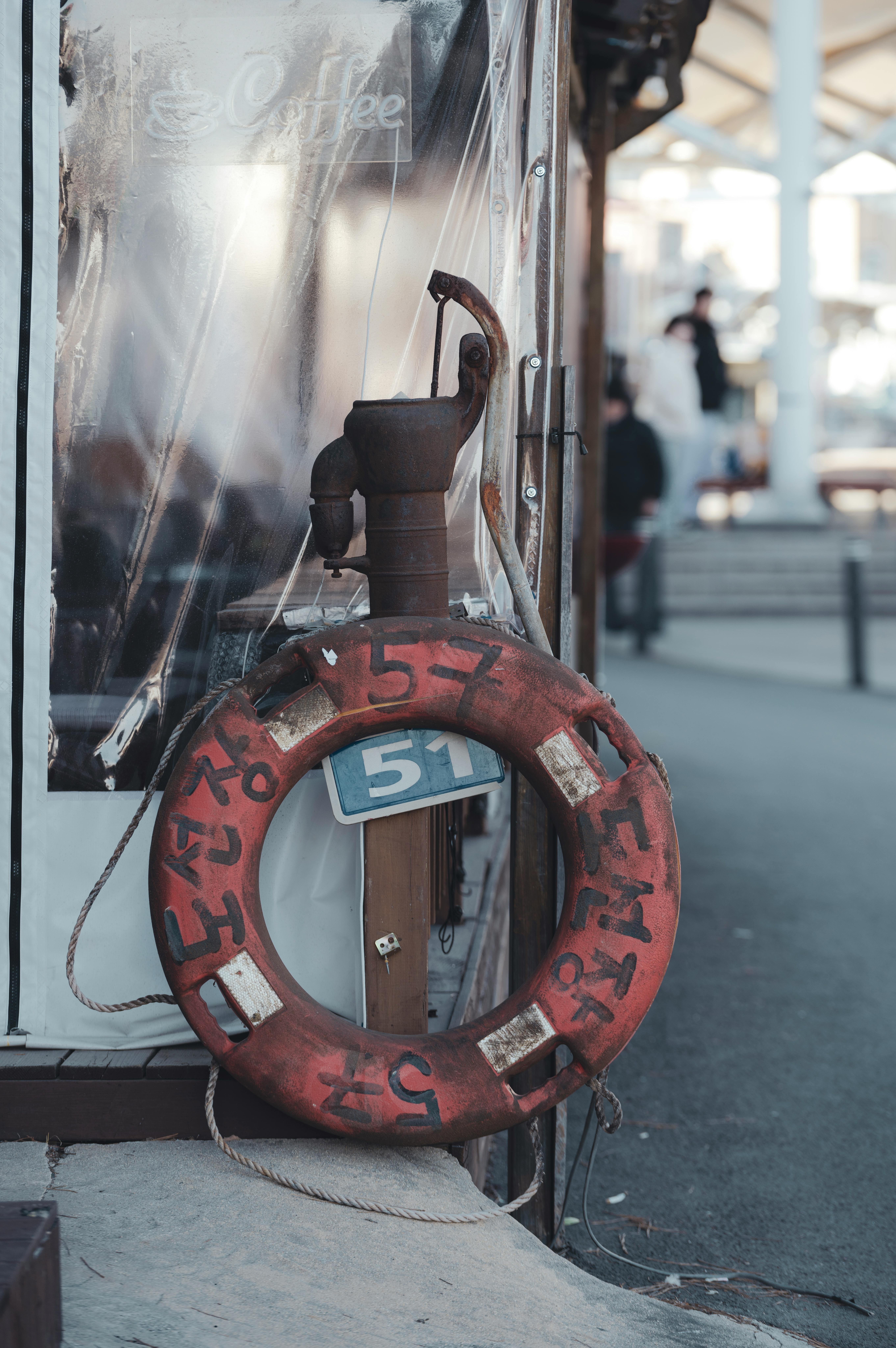 Kostnadsfria En rustik livbojsring med koreansk text hängande vid bryggan, som visar upp maritim charm. Stock foto
