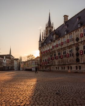 The historic Gouda City Hall stands illuminated by a vibrant sunset in Gouda, Netherlands.