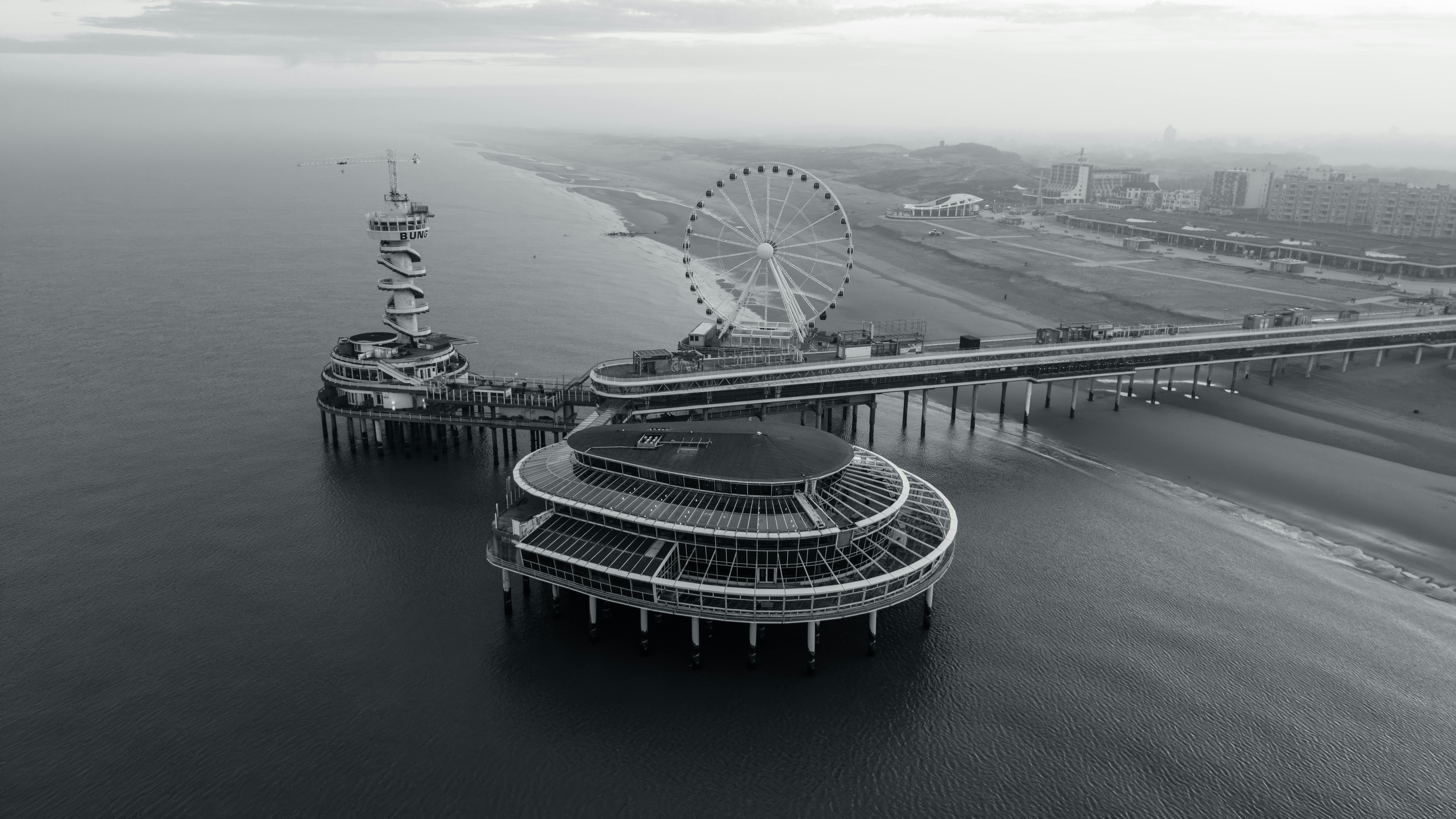 Captivating aerial view of Scheveningen Pier with Ferris wheel in monochrome.