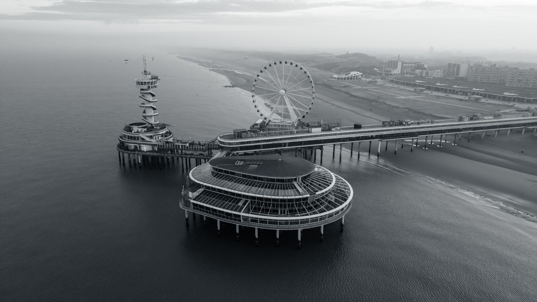 Captivating aerial view of Scheveningen Pier with Ferris wheel in monochrome.