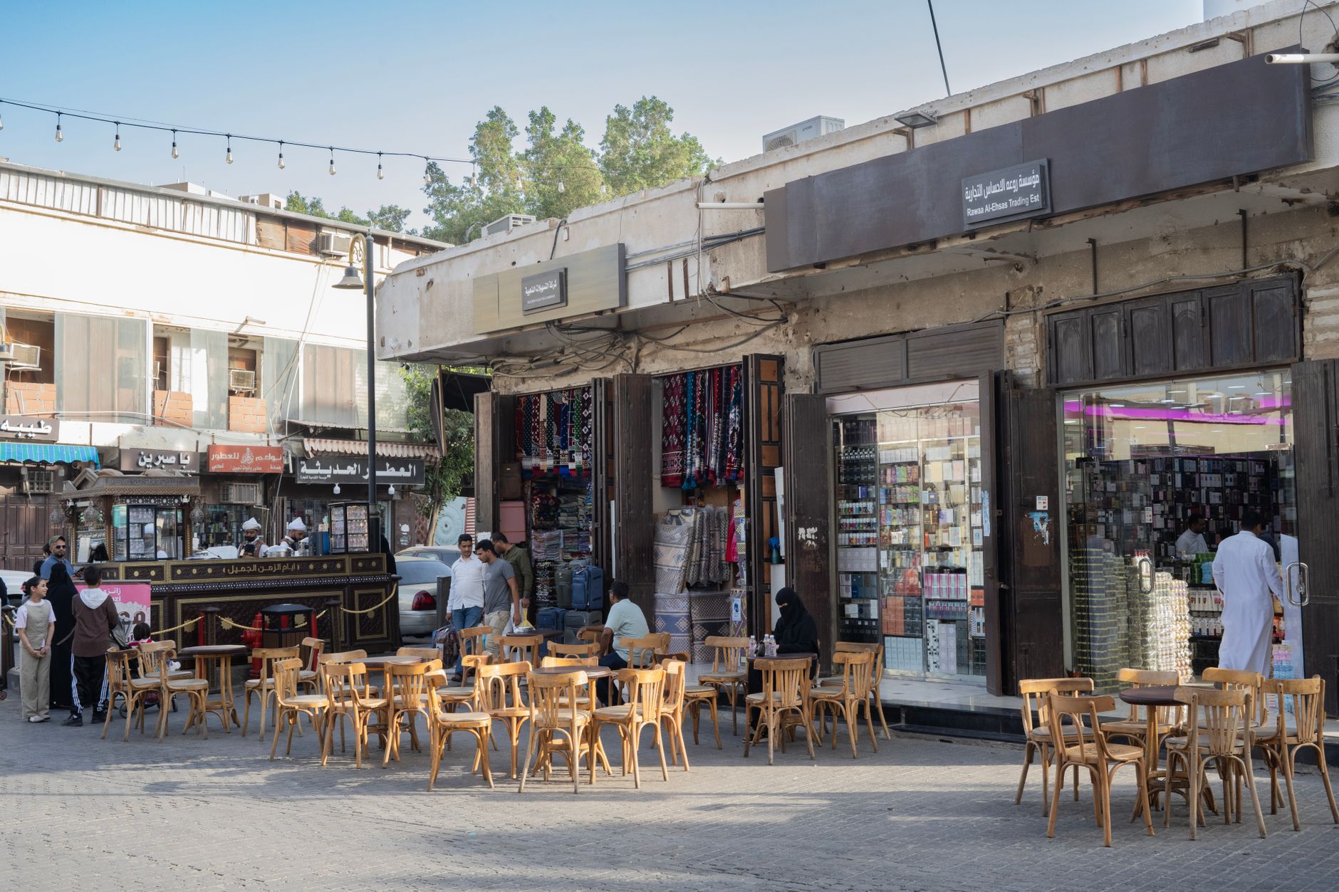 Lively Middle Eastern market scene with outdoor seating and local shops, capturing vibrant local culture.