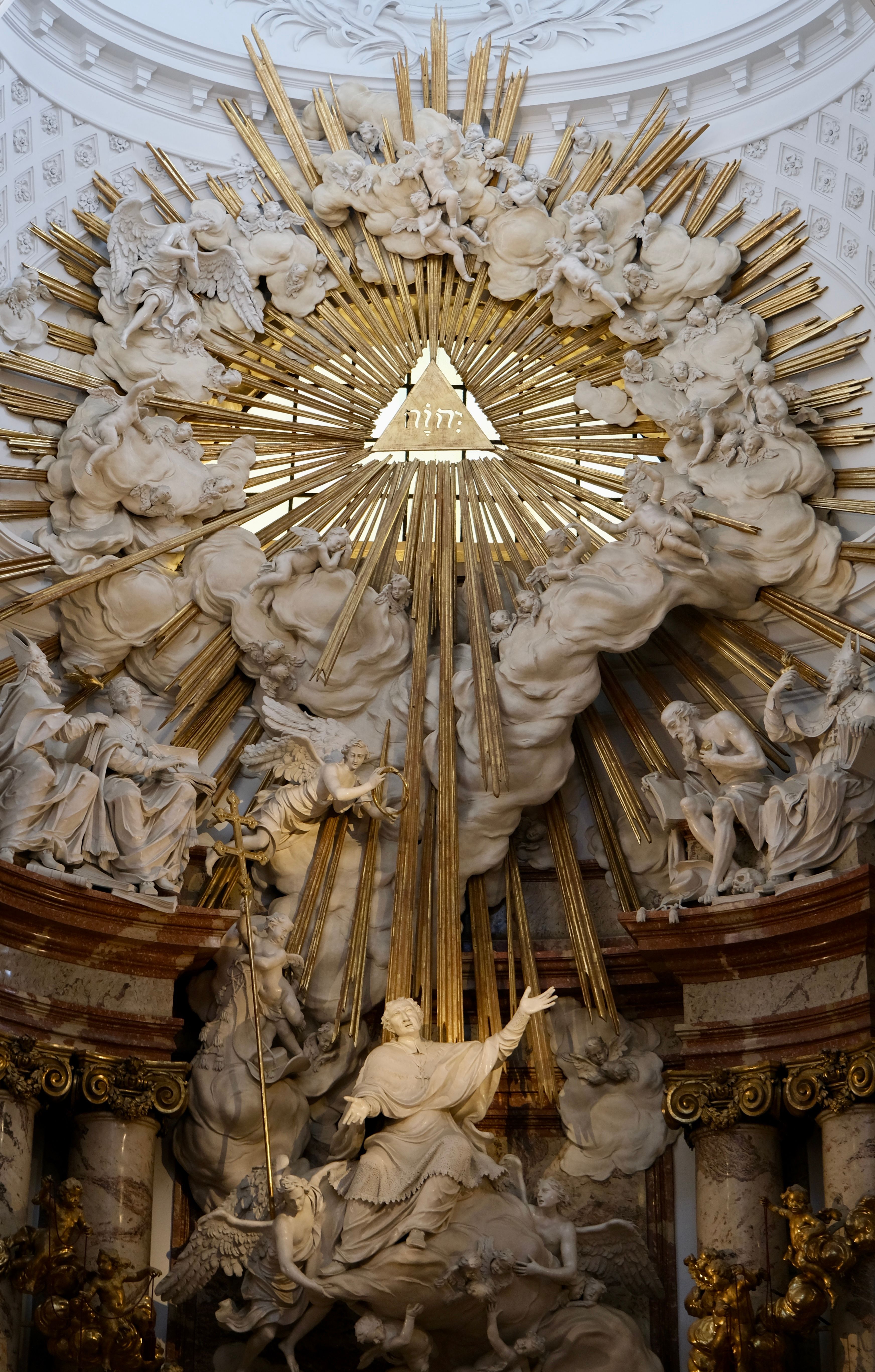 Intricate Baroque church sculpture with dramatic light rays and religious symbolism.