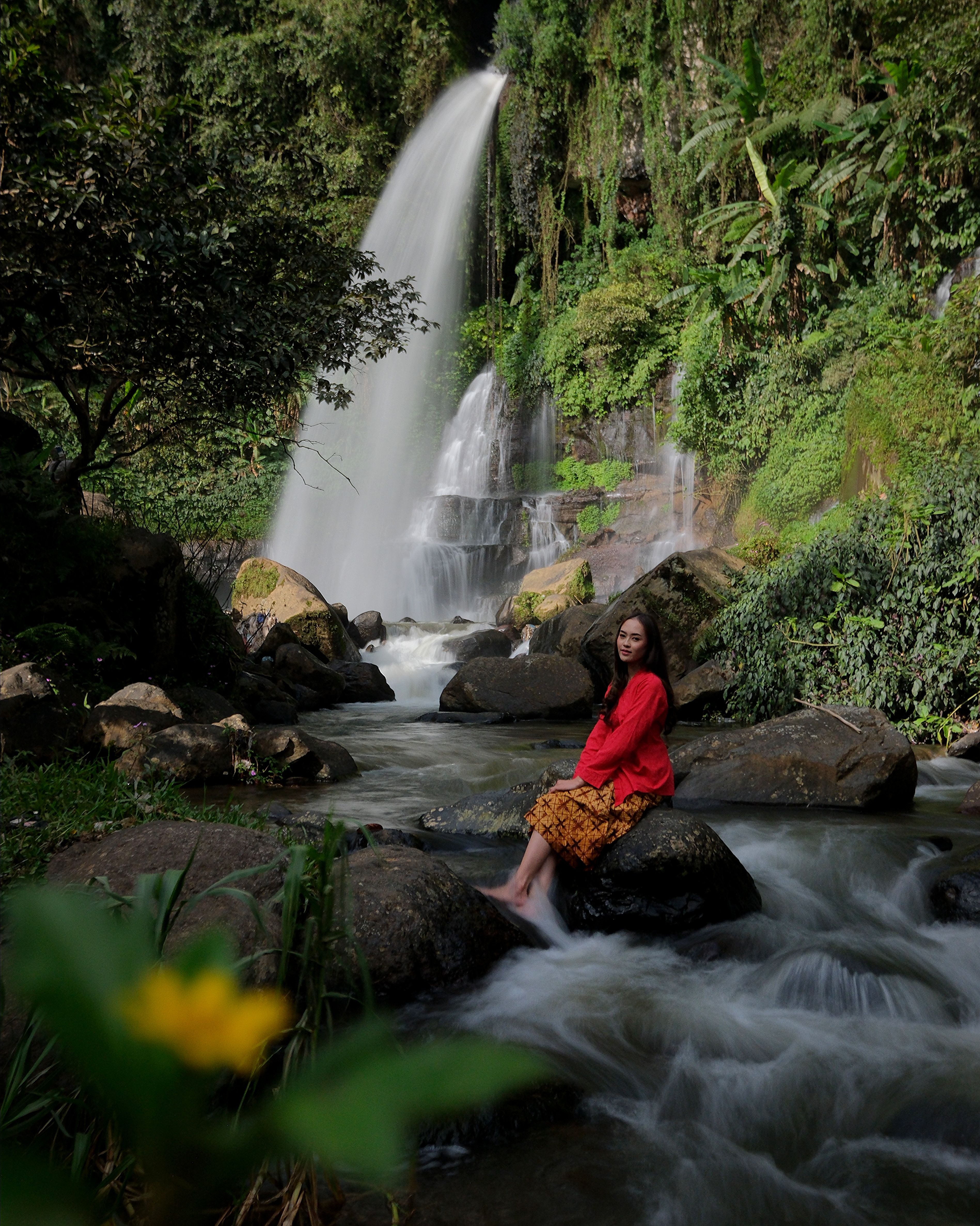 Woman Enjoying Waterfall in Lush Forest