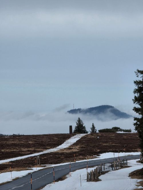 Free A serene winter scene capturing a snow-covered road leading into the Vosges mountains. Stock Photo