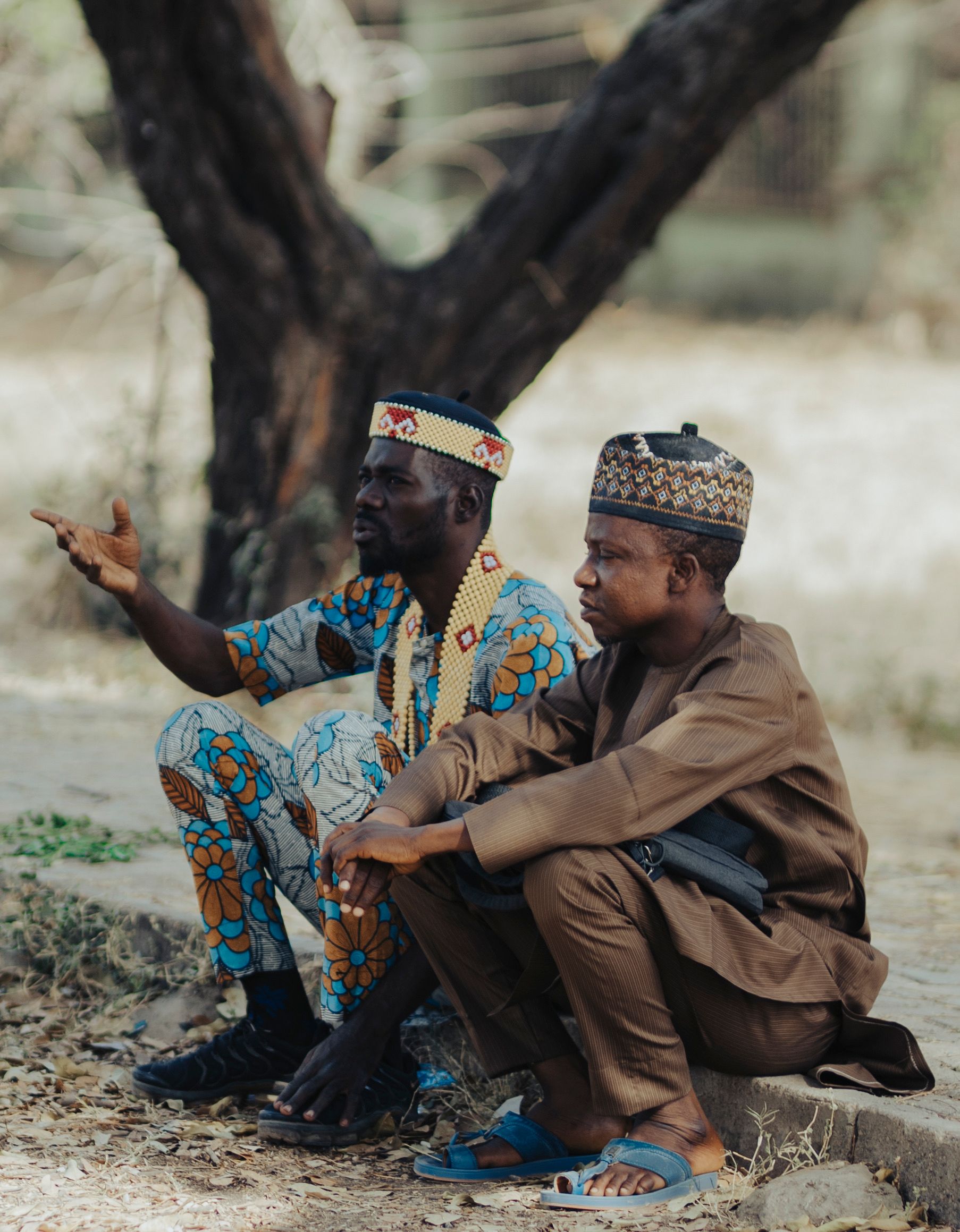 Two Men Talking in Traditional African Attire Outdoors · Free Stock Photo