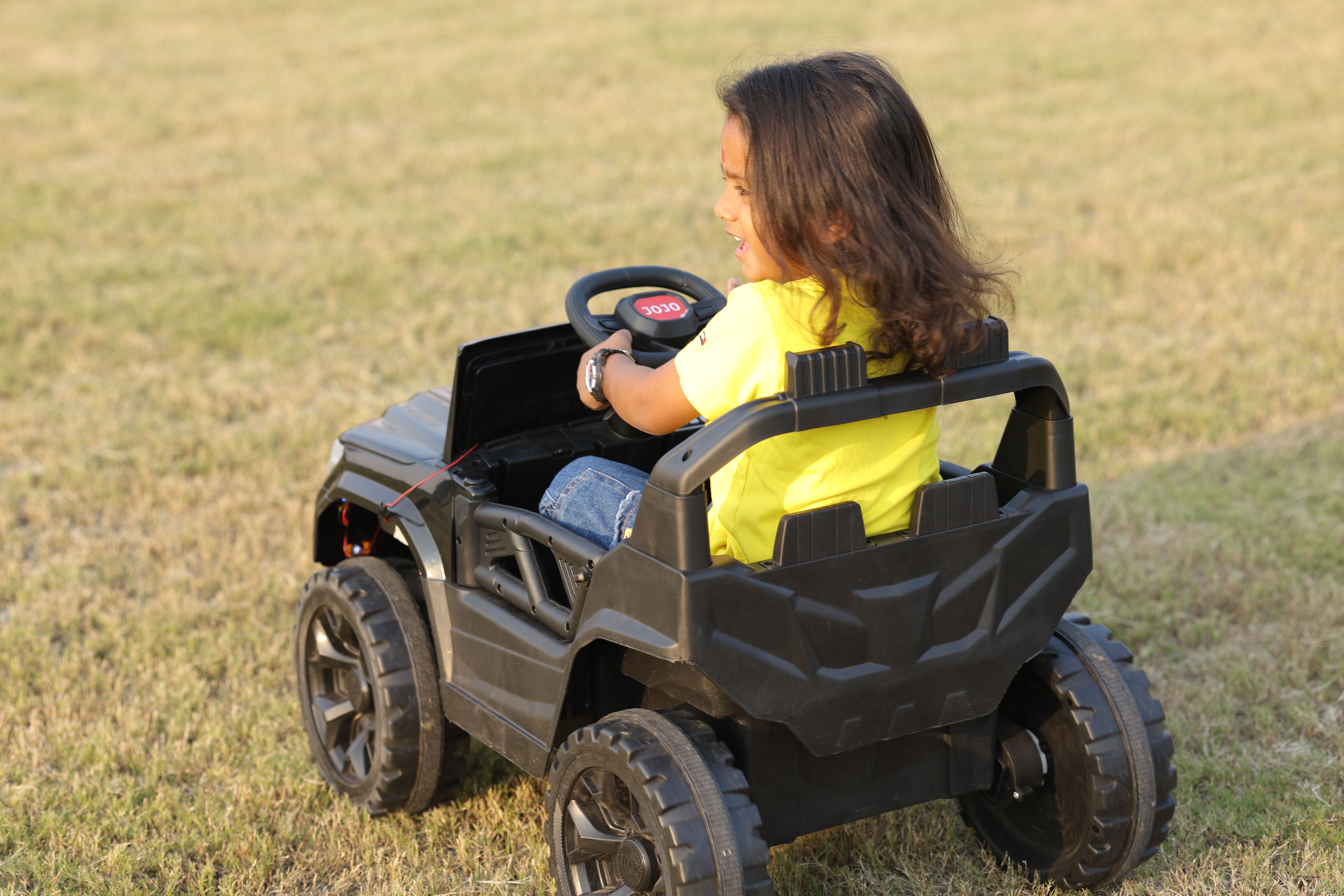 Child Enjoying a Toy Car Ride Outdoors · Free Stock Photo