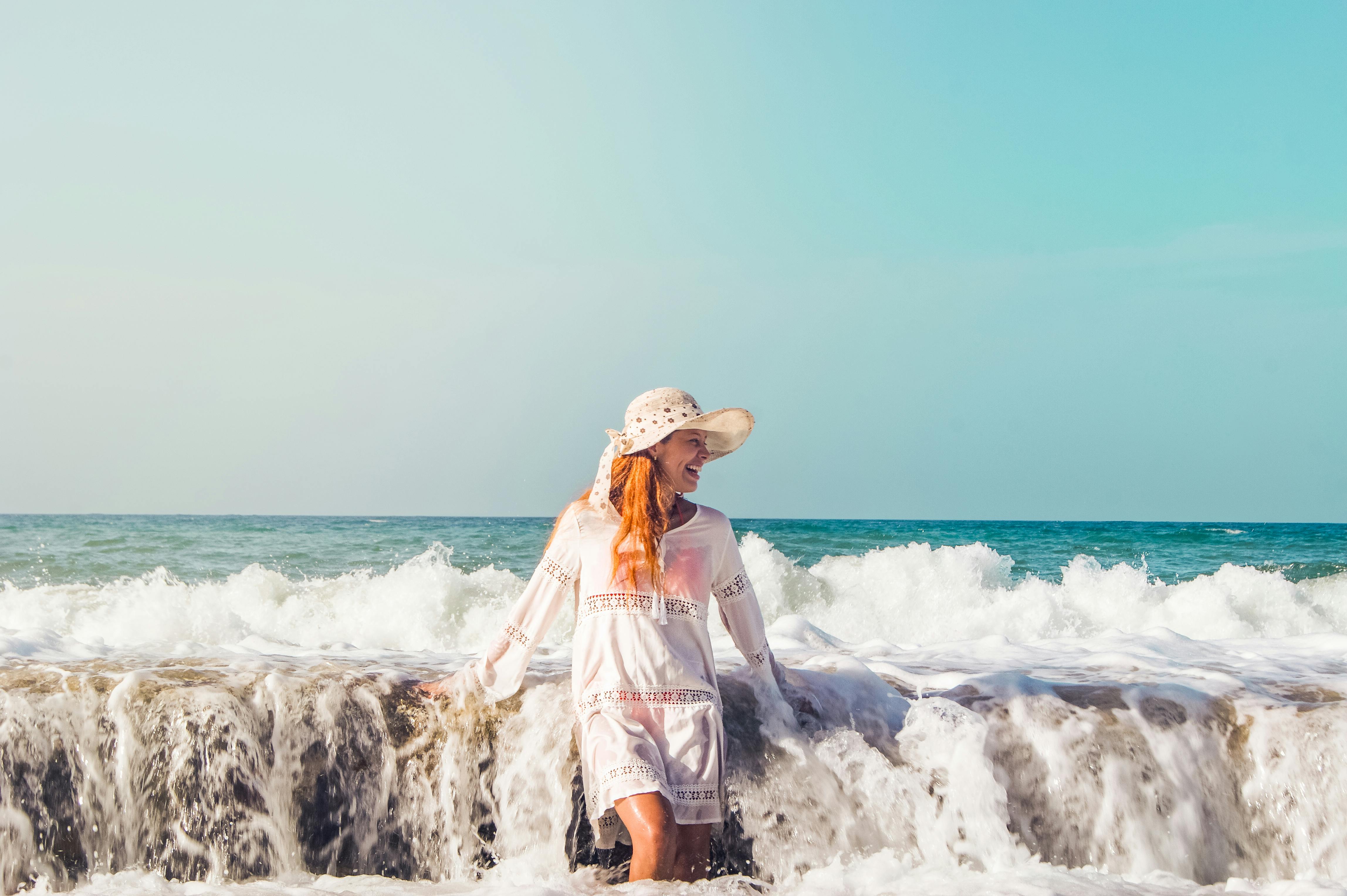 A woman in a sun hat enjoys the waves at La Sabana Beach, Venezuela.