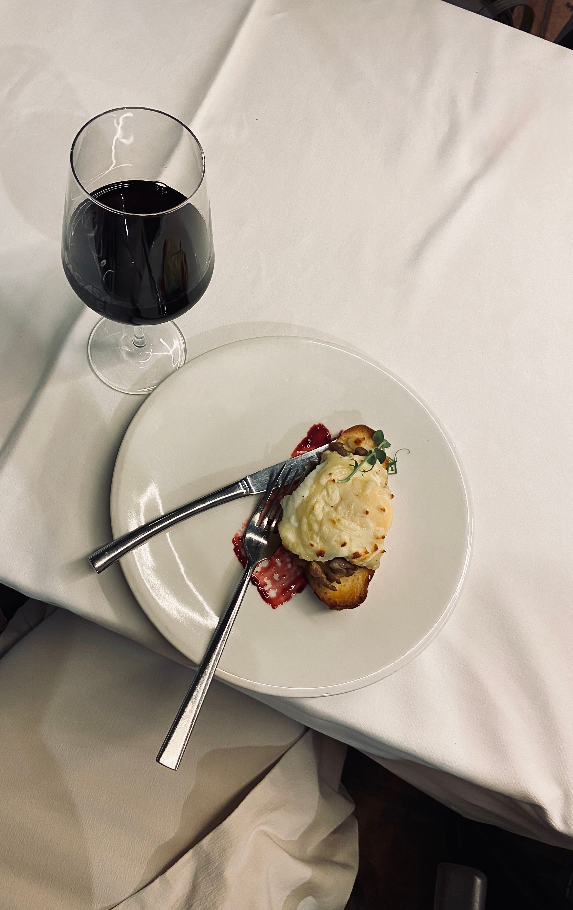 Gratis Elegante apparecchiatura da tavola con piatto gourmet e vino rosso, perfetta per un'atmosfera raffinata. Foto a disposizione