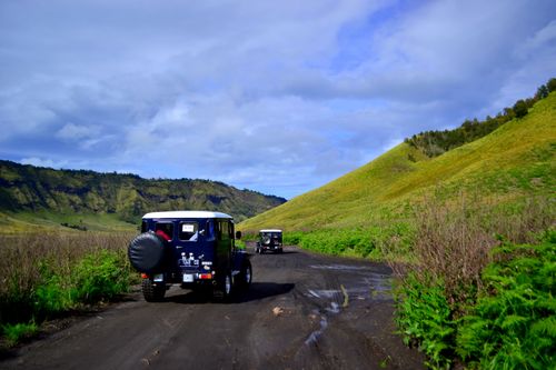 Free Adventure jeeps traverse the rugged volcanic terrain in East Java, Indonesia, offering a scenic journey. Stock Photo