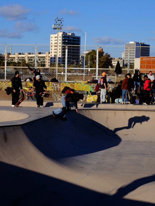 Free Skateboarders in action at a lively Barcelona skatepark, surrounded by urban architecture. Stock Photo