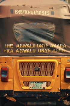 Close-up of a vibrant tuk-tuk with local writing in Enugu, Nigeria.