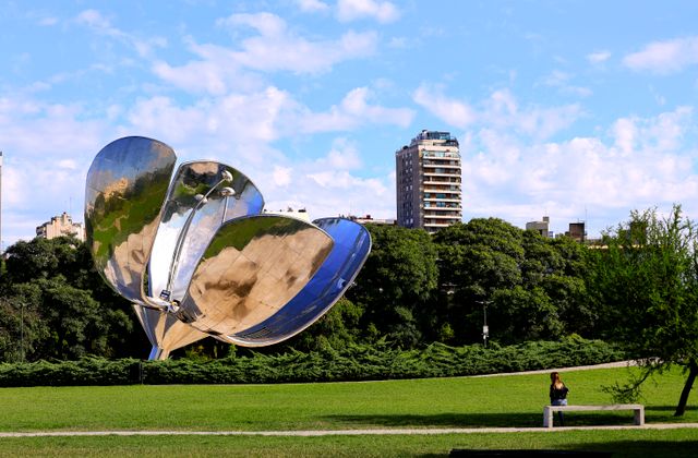 Floralis Generica sculpture in a Buenos Aires park with buildings in the background. — arriving in Buenos Aires