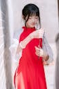 Teen girl in traditional red clothing holding beads