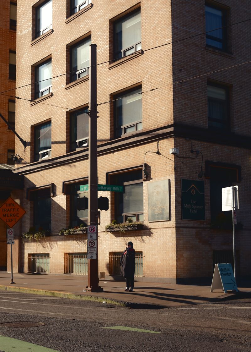 A person walking across the street in front of a tall building · Free ...