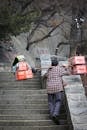 Man Carrying Goods Up Stone Stairs