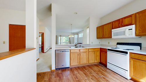Free Bright modern kitchen featuring wooden cabinets and stainless steel appliances. Stock Photo