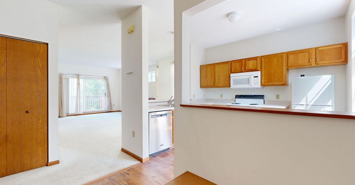 Spacious open-plan kitchen and living area with wood accents and neutral colors.