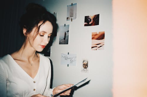 Woman in White Scoop Neck Shirt Holding a Paper