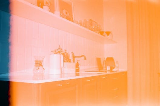 Aesthetic film photography of a modern kitchen with a colorful light leak effect.