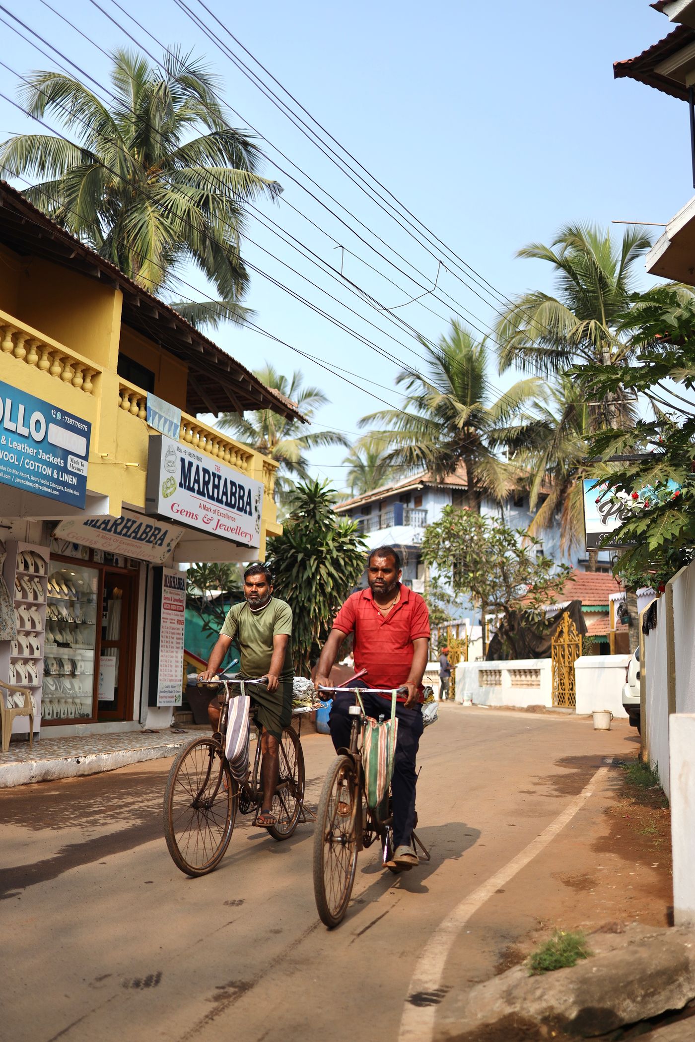 Temporary development photograph of cyclists travelling through a tropical Indian street