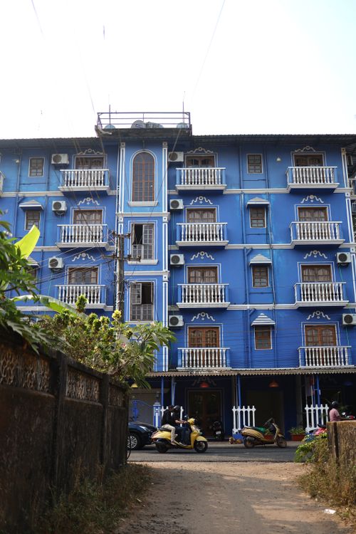 Free Vibrant blue residential building in Goa, India with ornate balconies and street view. Stock Photo
