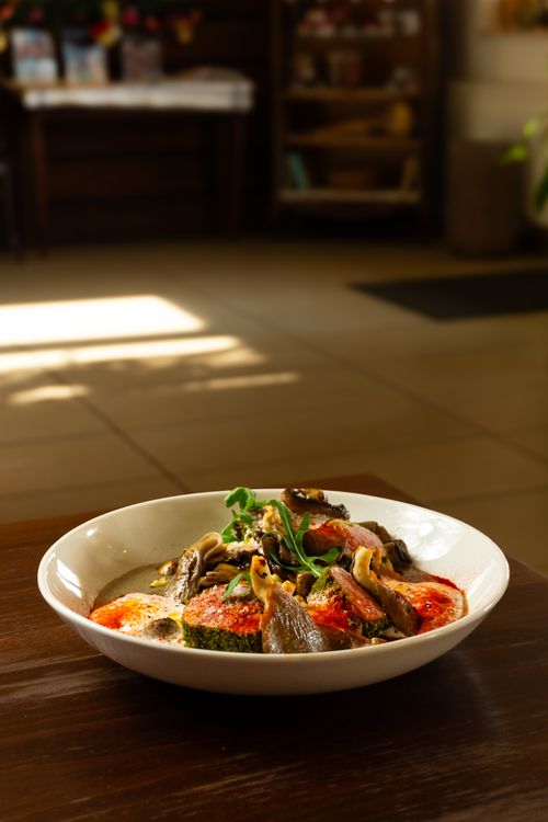 Free A gourmet vegetable dish with mushrooms served indoors in a cozy, light-filled setting. Stock Photo