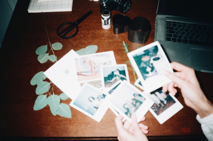 Person Holding Instant Photos