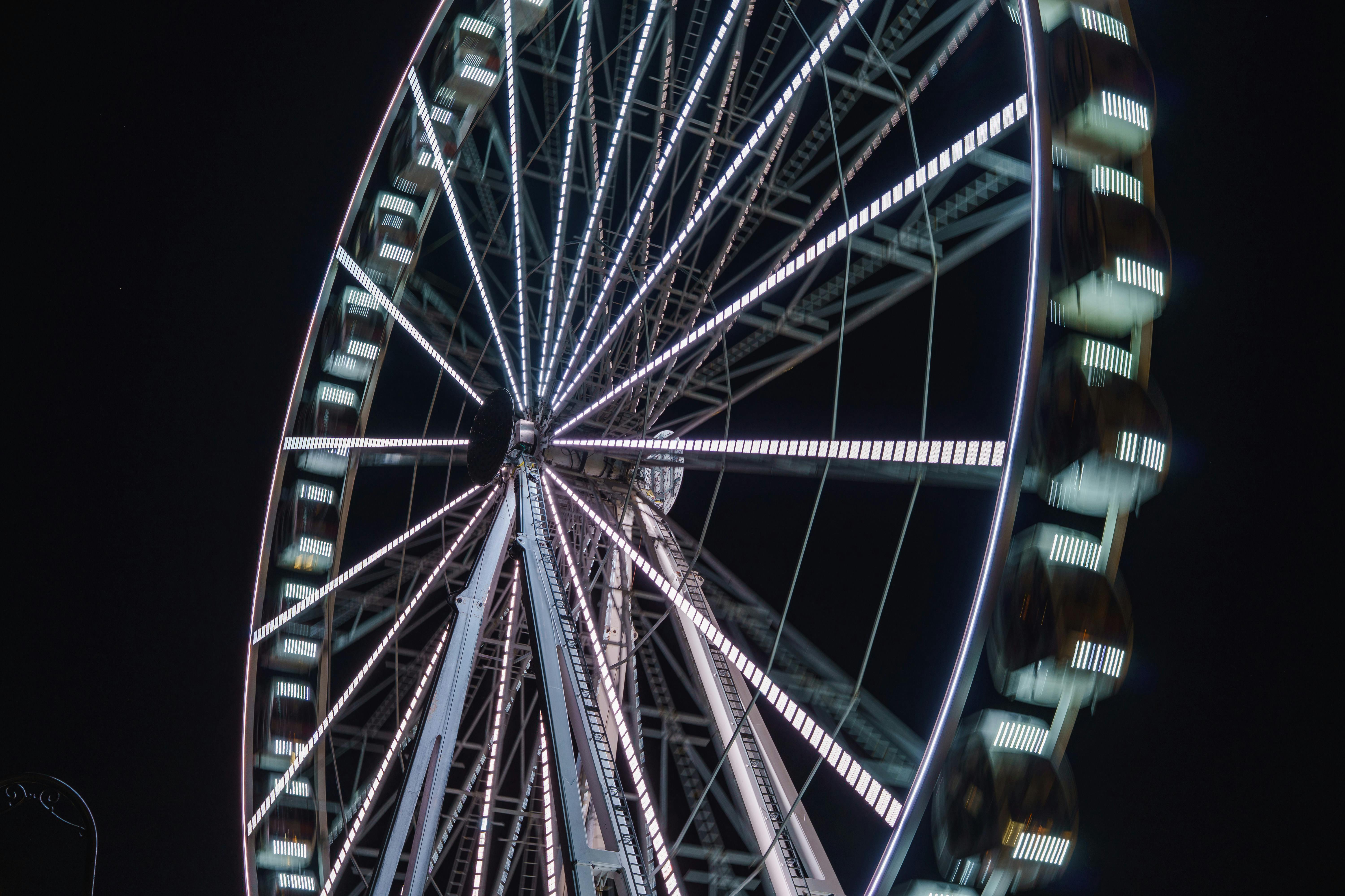 Безкоштовне Приголомшливий вид освітленого колеса огляду на тлі нічного неба, що створює вражаючу візуальну картину. стокове фото