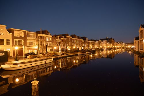 Free Captivating view of illuminated canal and buildings in Leiden at night. Stock Photo