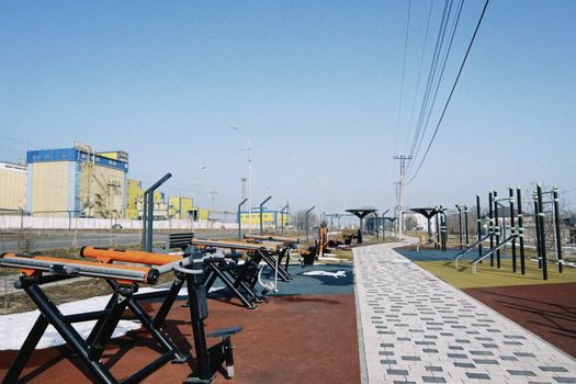 Modern outdoor fitness park with benches and gym equipment in Konaev, Almaty Region, Kazakhstan.