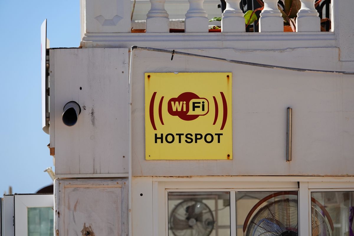Placa galbena cu inscriptia wifi hotspot pe fatada unei cladiri