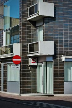 Contemporary urban building facade with a prominent no entry sign and glass windows.