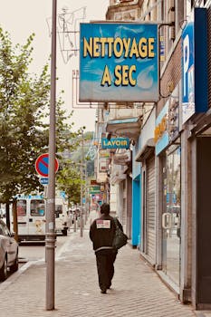 A city street with a 'Nettoyage à Sec' dry cleaning sign, capturing the essence of urban life.