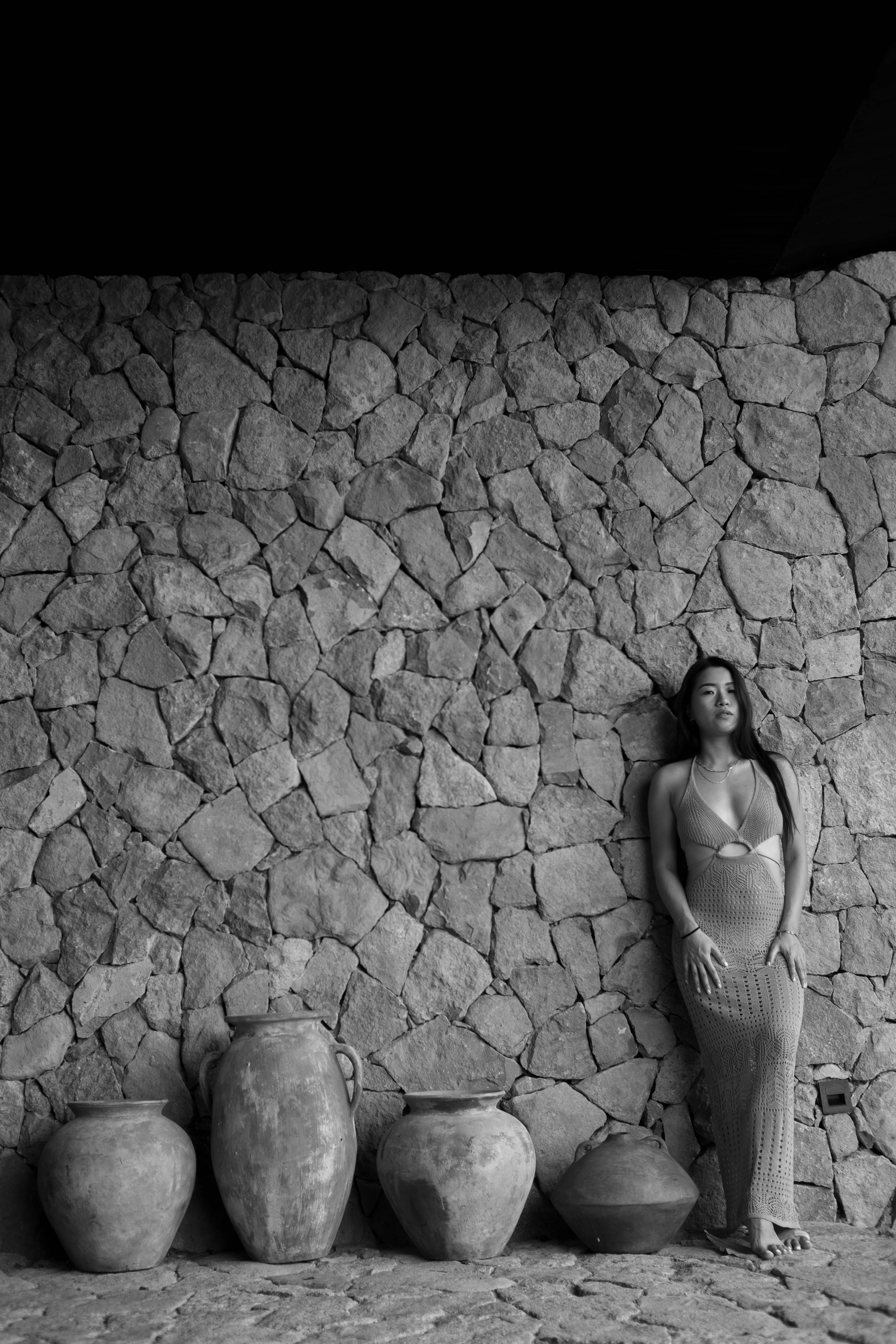 Elegant Woman Leaning Against Stone Wall · Free Stock Photo