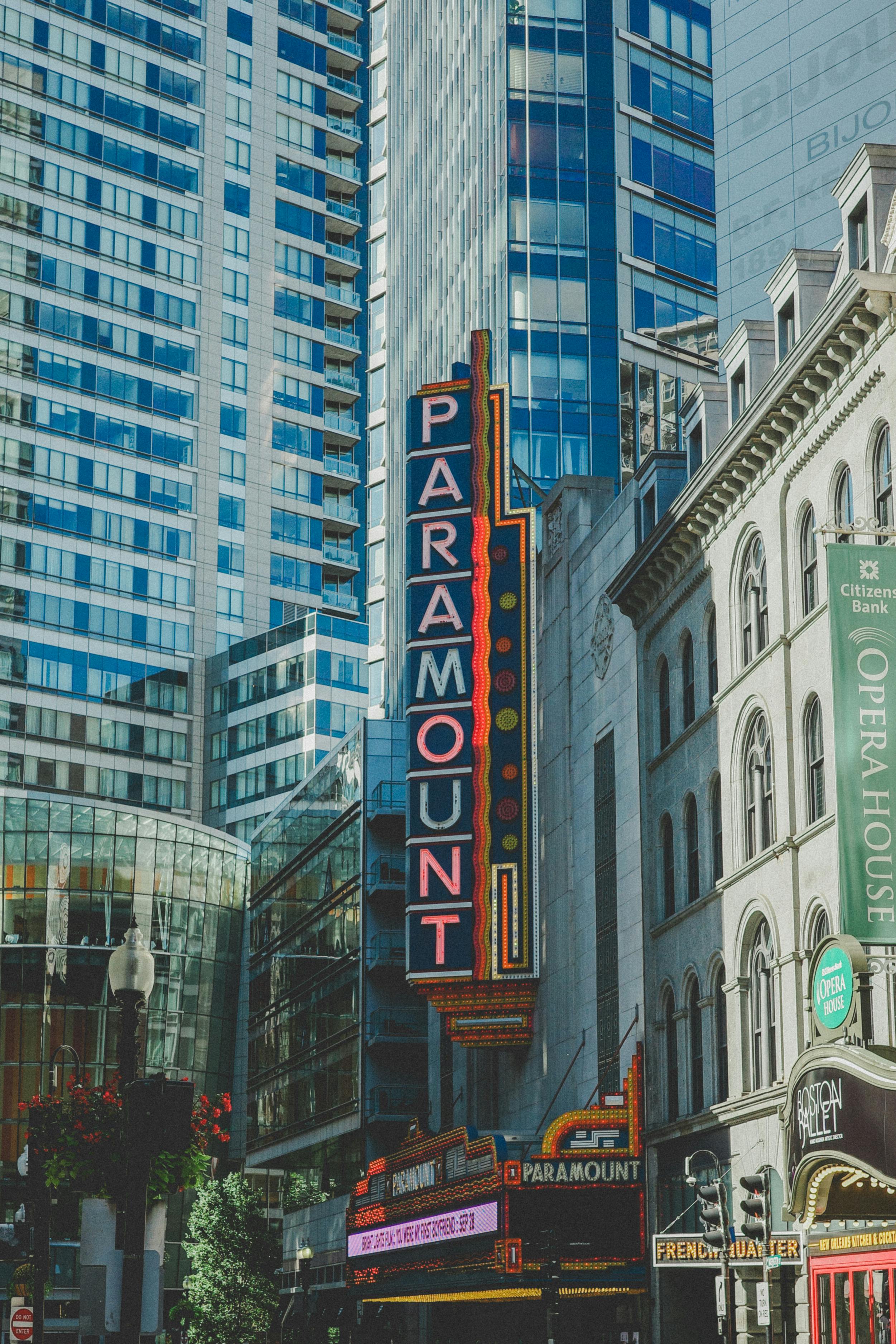 Gratis Fotografi av Paramount Theatre-skiltet omgitt av skyskrapere i et bymiljø. Arkivbilde