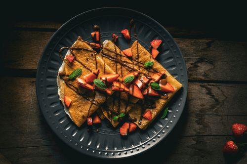 Free Top view of strawberry-topped crepes drizzled with chocolate, perfect for breakfast inspiration. Stock Photo
