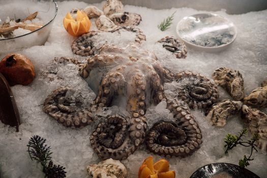 Chilled octopus and seafood on a bed of ice at a market.