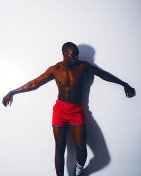 A striking image of an African male athlete posing energetically against a neutral background.