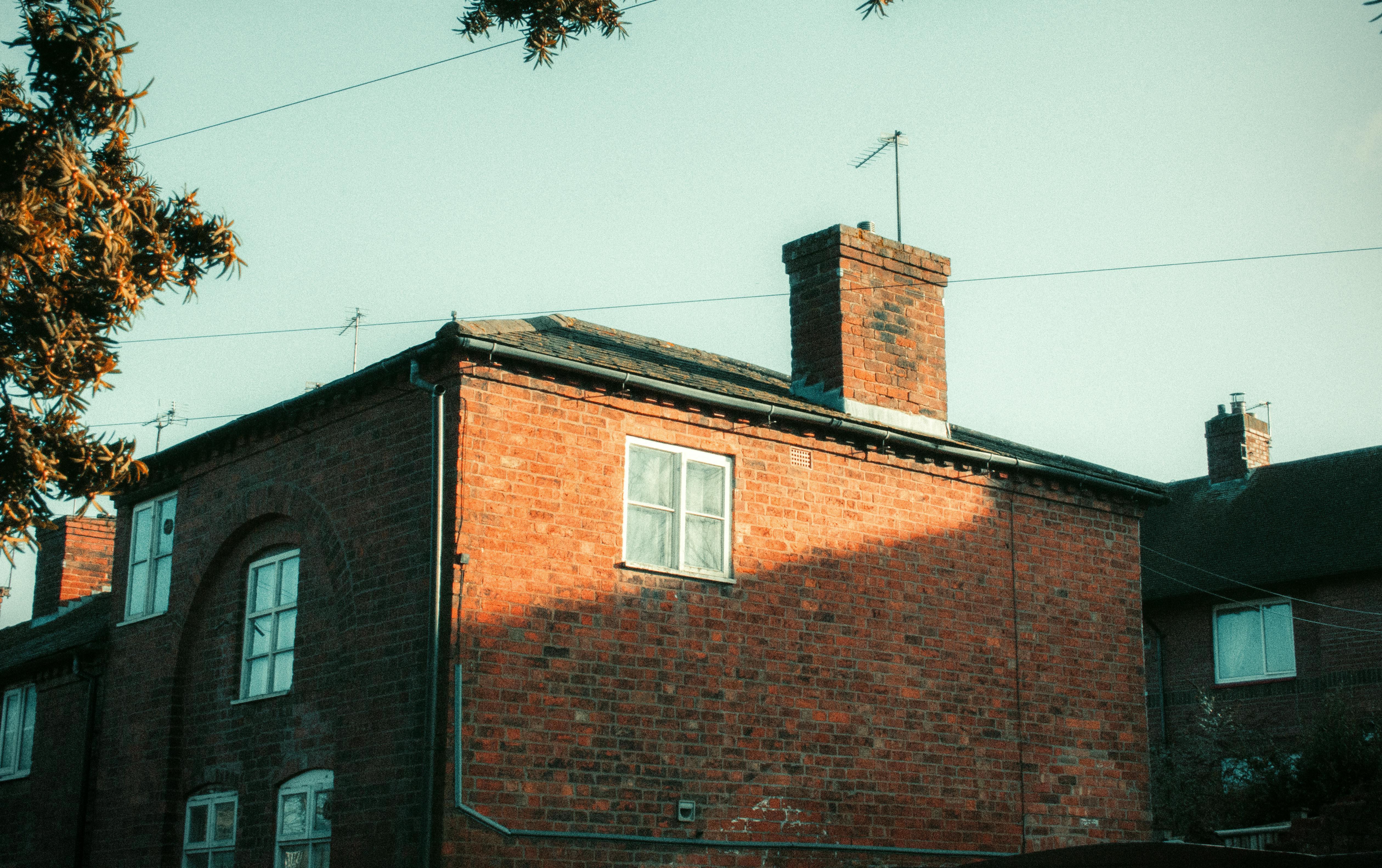grátis Charmosa arquitetura de tijolos iluminada pela luz quente do sol da tarde na Inglaterra. Foto profissional