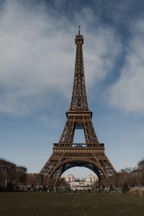 Free Capture of the Eiffel Tower in Paris under a dramatic, moody sky, highlighting its architectural elegance. Stock Photo