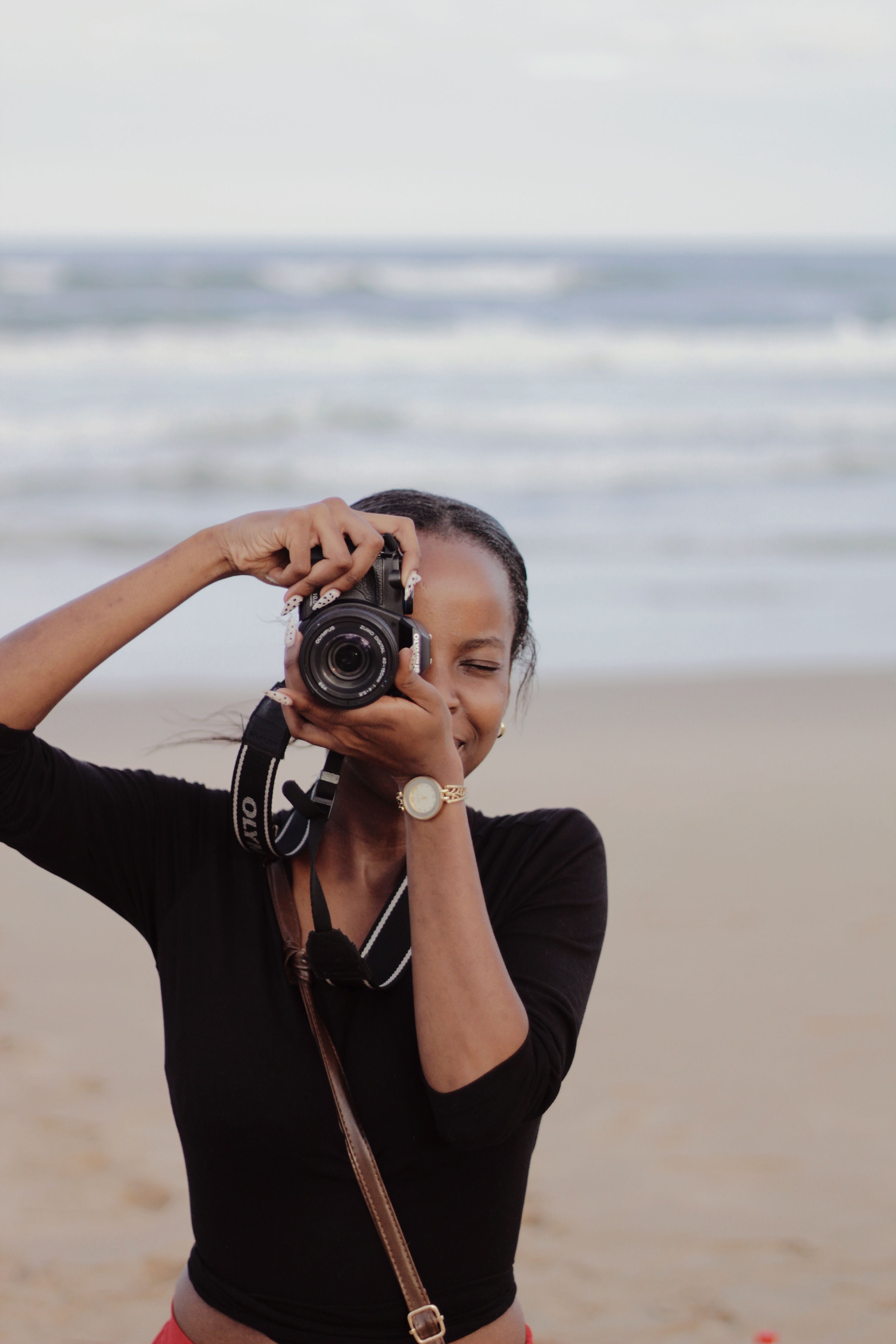 A woman photographer with a camera capturing a serene moment on Durban's beautiful beach.